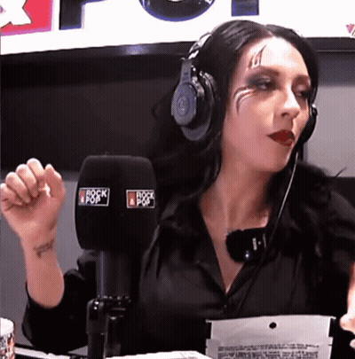 A Woman Wearing Headphones Is Talking Into A Microphone That Says Rock Pop GIF