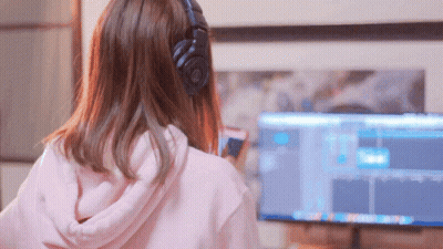 A Woman Wearing Headphones Looks At A Computer Monitor GIF