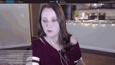 A Woman Wearing Headphones Looks At The Camera While Playing A Game GIF