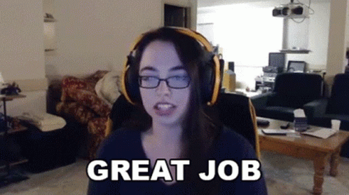 A Woman Wearing Headphones Says " Great Job " In A Living Room GIF