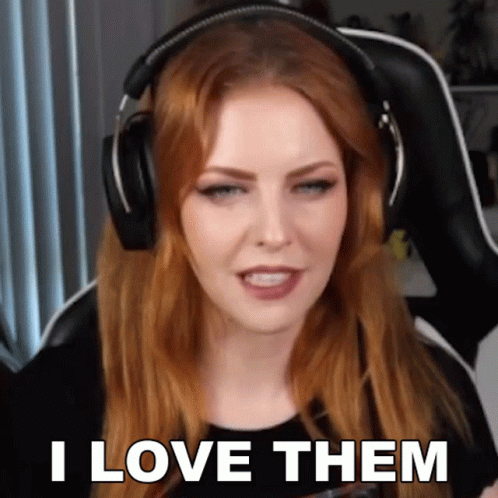 A Woman Wearing Headphones Says " I Love Them " While Sitting In A Chair . GIF