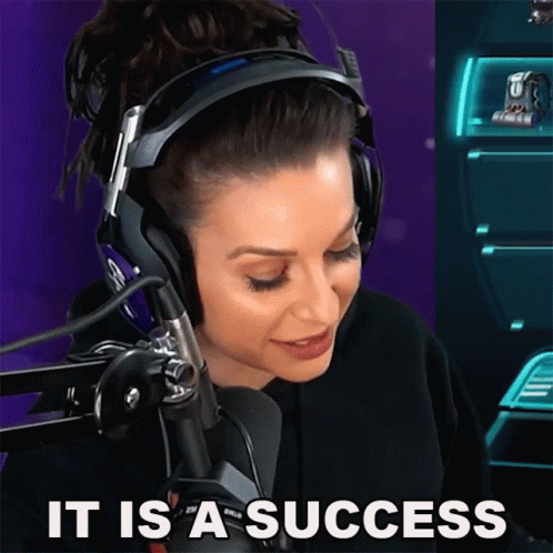 A Woman Wearing Headphones Says " It Is A Success " In Front Of A Microphone GIF