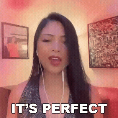 A Woman Wearing Headphones Says It 'S Perfect In Front Of A Pink Wall GIF
