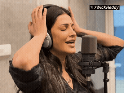 A Woman Wearing Headphones Singing Into A Microphone With A 7Wickreddy Logo In The Corner GIF