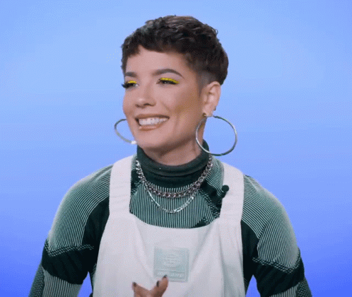 A Woman Wearing Hoop Earrings And An Apron With The Word Dickies On It Smiles GIF