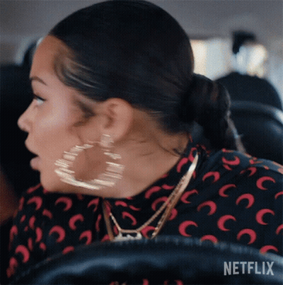 A Woman Wearing Hoop Earrings Is Sitting In A Car With Netflix Written On The Bottom Of The Screen GIF