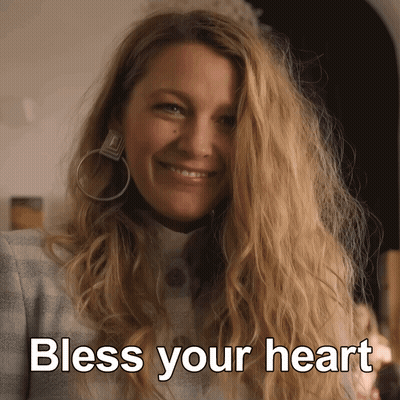 A Woman Wearing Hoop Earrings Smiles With The Words Bless Your Heart Above Her GIF