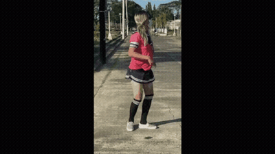 A Woman Wearing Knee High Socks And A Pink Shirt Is Standing On A Sidewalk GIF