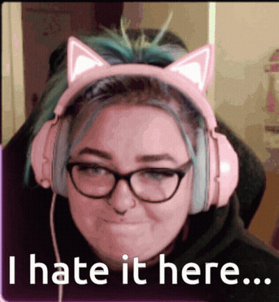 A Woman Wearing Pink Headphones With Cat Ears And Glasses Says I Hate It Here GIF