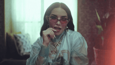A Woman Wearing Pink Sunglasses And A Necklace With The Letter N On It GIF