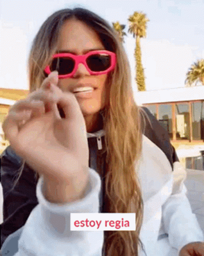 A Woman Wearing Pink Sunglasses And A White Jacket Says Estoy Regia In Spanish . GIF
