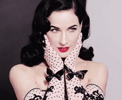 A Woman Wearing Polka Dot Gloves With A Bow On The Cuffs GIF