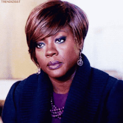 A Woman Wearing Purple Lipstick And Earrings Is Making A Face . GIF