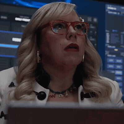 A Woman Wearing Red Glasses And A Necklace Says What GIF