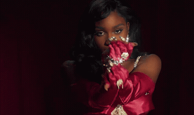 A Woman Wearing Red Gloves And A Necklace With Diamonds GIF