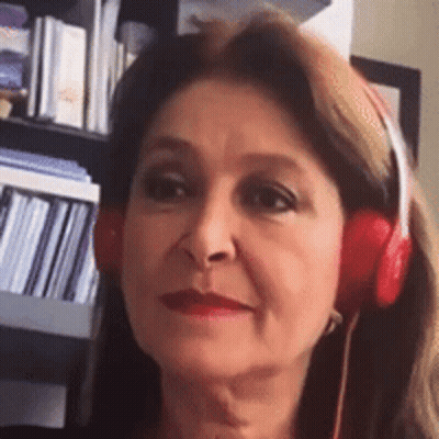 A Woman Wearing Red Headphones Is Smiling In Front Of A Bookshelf . GIF