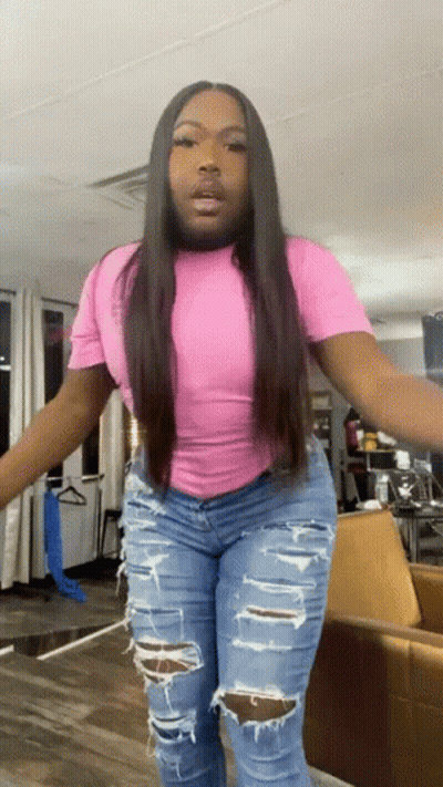 A Woman Wearing Ripped Jeans And A Pink Shirt GIF