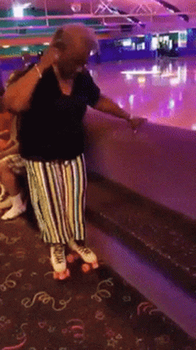 A Woman Wearing Roller Skates Is Standing On A Carpet That Says ' Swirls ' On It GIF