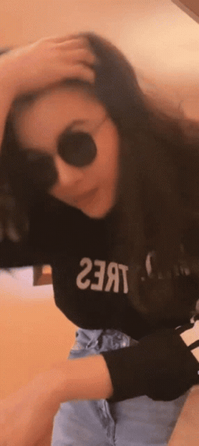 A Woman Wearing Sunglasses And A Black Shirt That Says ' 23 ' On It GIF