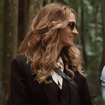 A Woman Wearing Sunglasses And A Black Suit Jacket GIF