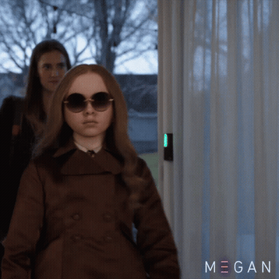 A Woman Wearing Sunglasses And A Brown Coat Is Standing Next To Another Woman And The Word Megan Is On The Bottom Right GIF