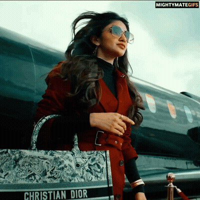 A Woman Wearing Sunglasses And A Christian Dior Purse GIF