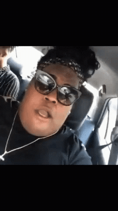 A Woman Wearing Sunglasses And A Headband Is In A Car . GIF