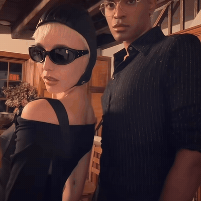 A Woman Wearing Sunglasses And A Helmet Stands Next To A Man GIF