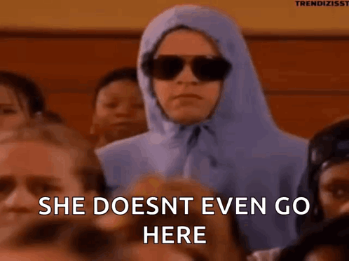 A Woman Wearing Sunglasses And A Hooded Jacket Is Sitting In A Crowd Of People And Says She Does Nt Even Go Here GIF