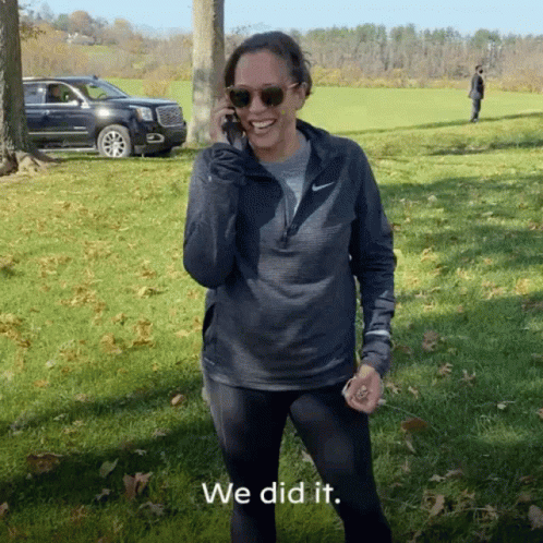 A Woman Wearing Sunglasses And A Nike Jacket Talks On A Cell Phone GIF