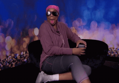 A Woman Wearing Sunglasses And A Pink Headband Sitting On A Couch GIF