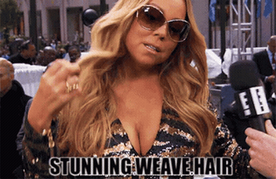 A Woman Wearing Sunglasses And A Plunging Neckline Is Being Interviewed By A Reporter . GIF
