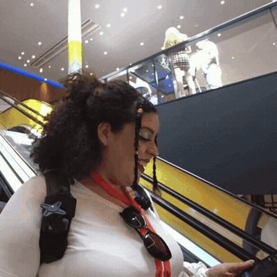 A Woman Wearing Sunglasses And A Red Lanyard With A Star On It GIF