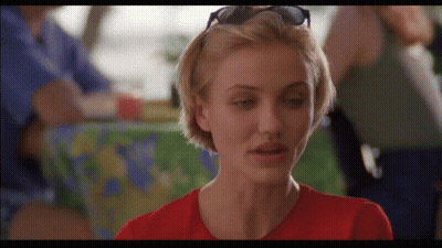 A Woman Wearing Sunglasses And A Red Shirt Is Looking At The Camera GIF