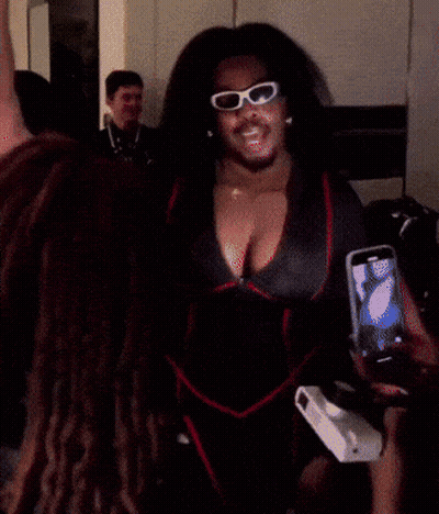 A Woman Wearing Sunglasses And A Robe Is Taking A Selfie GIF