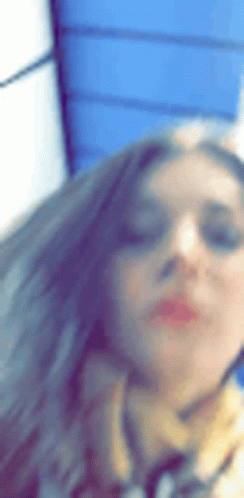 A Woman Wearing Sunglasses And A Scarf Is Taking A Picture Of Herself . GIF