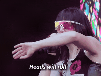 A Woman Wearing Sunglasses And A Shirt That Says Heads Will Roll GIF