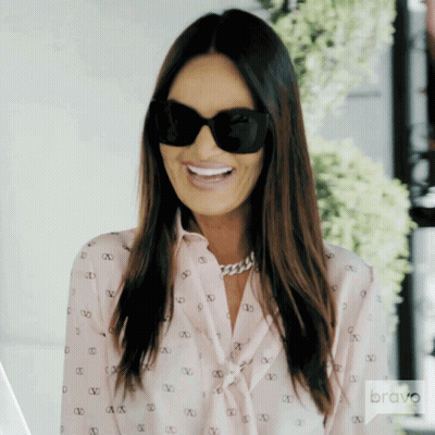 A Woman Wearing Sunglasses And A Shirt With The Word Bravo On The Bottom GIF