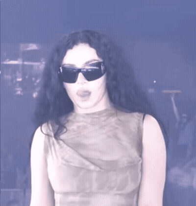 A Woman Wearing Sunglasses And A Sleeveless Top GIF