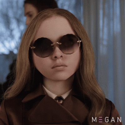 A Woman Wearing Sunglasses And A Trench Coat With Megan Written On The Bottom Right GIF