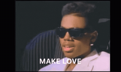 A Woman Wearing Sunglasses And A White Jacket With The Words Make Love Above Her GIF