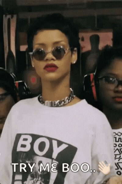 A Woman Wearing Sunglasses And A White Shirt That Says Boy Try Me Boo GIF