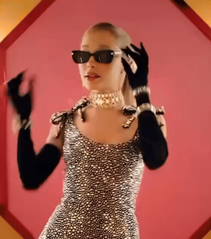 A Woman Wearing Sunglasses And Gloves Is Talking On A Cell Phone GIF