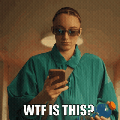 A Woman Wearing Sunglasses Is Holding A Bottle And Looking At Her Phone With The Words Wtf Is This Written Below Her GIF