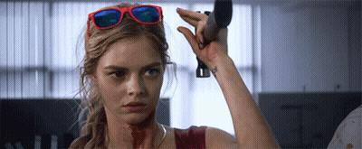 A Woman Wearing Sunglasses Is Holding A Knife GIF