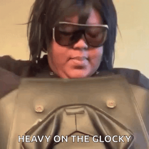 A Woman Wearing Sunglasses Is Holding A Leather Jacket And Says `` Heavy On The Glocky '' . GIF