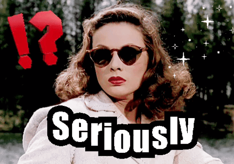 A Woman Wearing Sunglasses Is Next To A Sign That Says " Seriously " GIF