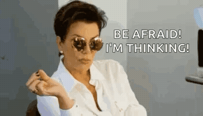 A Woman Wearing Sunglasses Is Sitting In A Chair And Saying `` Be Afraid ! I 'M Thinking '' . GIF