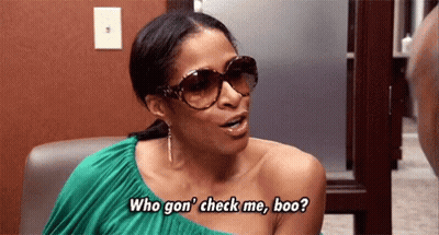 A Woman Wearing Sunglasses Is Sitting In A Chair And Talking To Someone . GIF