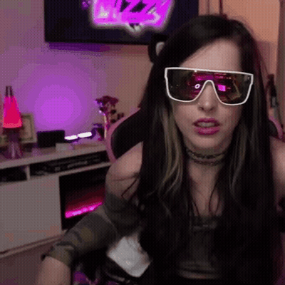 A Woman Wearing Sunglasses Is Sitting In A Chair In Front Of A Tv . GIF